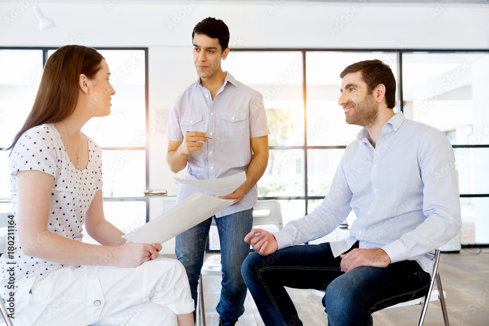 Image of business partners discussing documents and ideas Image of business partners discussing documents and ideas