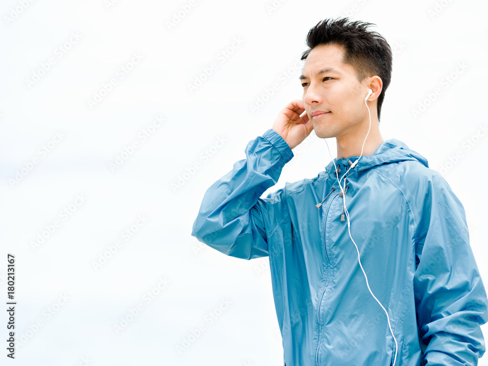 Sporty man with earphones on the sea coast Sporty man with earphones on the sea coast