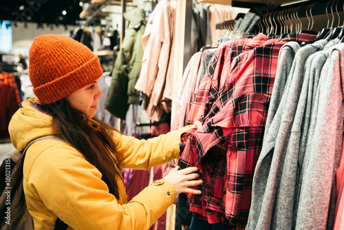 Woman shopping clothes. looking for new clothes in store