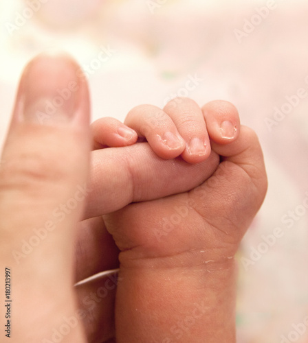 The baby clings to his father's finger © annatronova