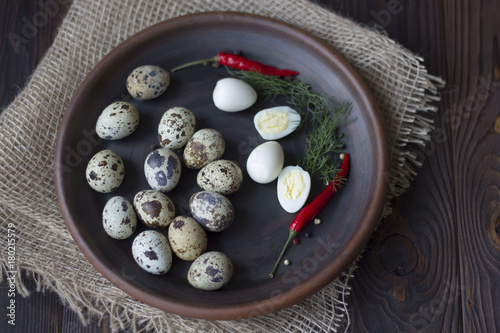 quail eggs, chili and spices on a wooden table