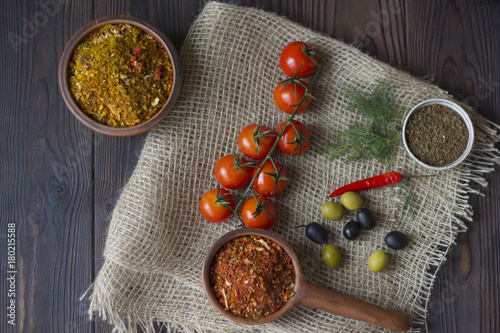 Vegetables and spices in a wooden table. tomatoes, olives, chili and spices close up. photo