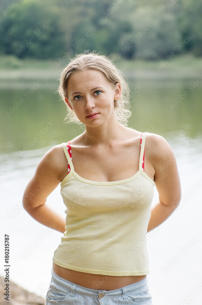 Girl in shorts and top, posing on the shore of the lake / Photo taken in Russia, in the countryside