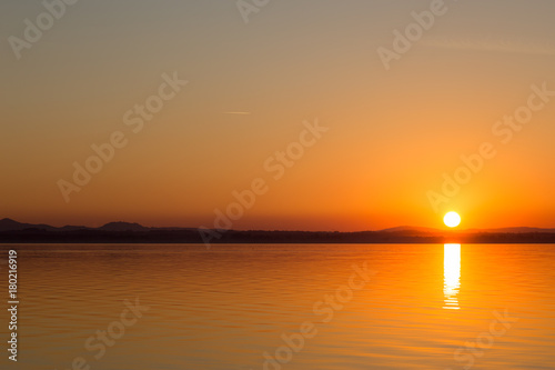 Classic sunset on a lake, with sun low on the horizon