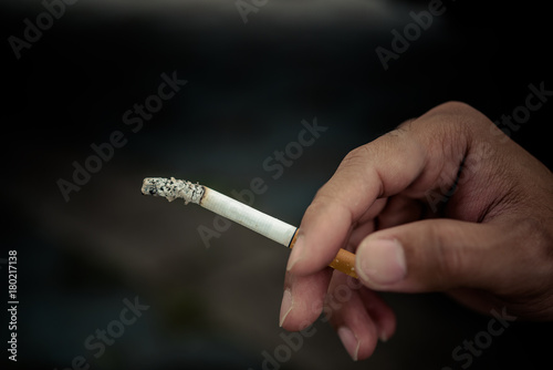Close up hand of asian handsome man holding cigarette