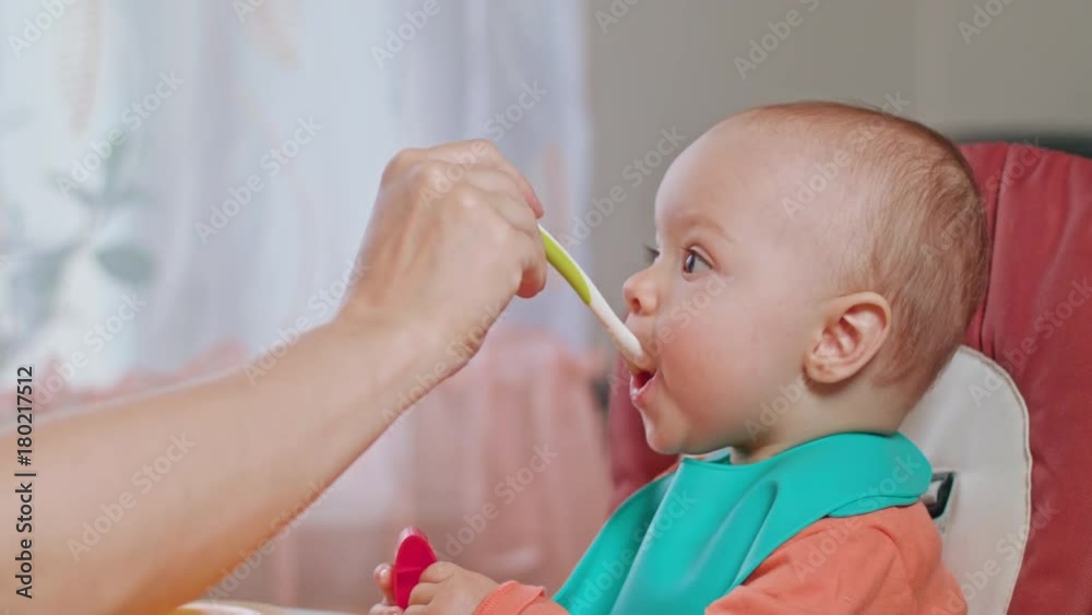 A baby girl eating puree at home. Medium shot. A baby girl eating puree at home. Medium shot.