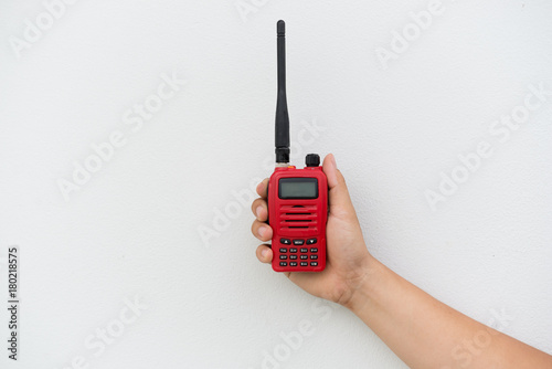 Red walkie talkie in hand on white background