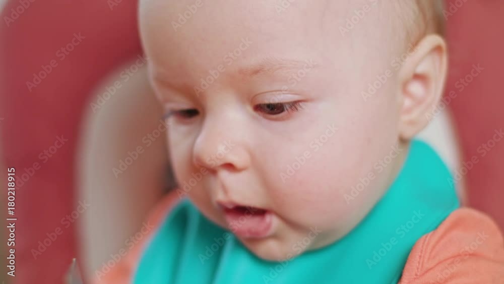 A baby girl eating puree at home. Close-up shot. Soft focus. A baby girl eating puree at home. Close-up shot. Soft focus.