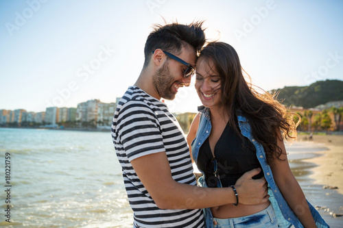 Happy man embracing his girlfriend leaning forehead on her head
