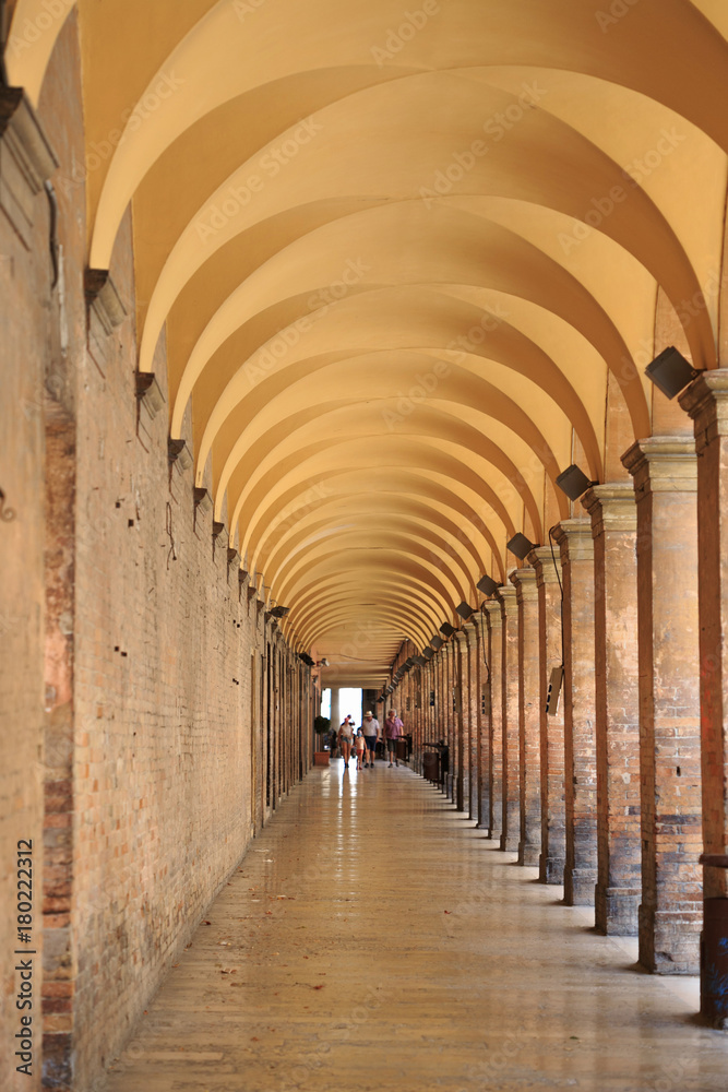 Urbino, Italy - August 9, 2017: Pedestrian zone near the building under an arch with columns