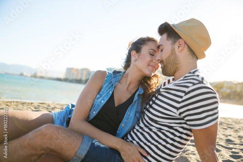 Happy couple sitting together on beach enjoying each other © innervisionpro