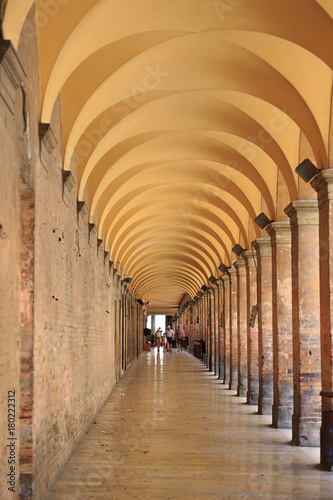 Urbino, Italy - August 9, 2017: Pedestrian zone near the building under an arch with columns photo