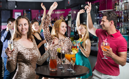 Young students dancing on party with cocktails