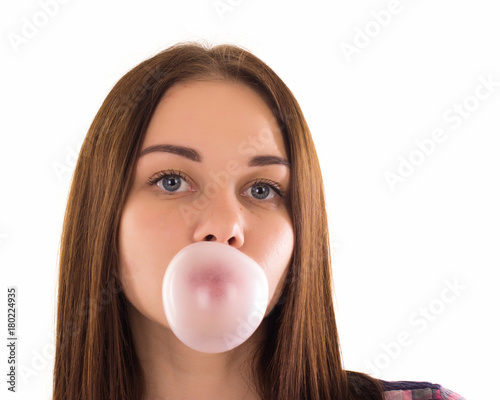 Young cute girl chews bubble gum, isolated  