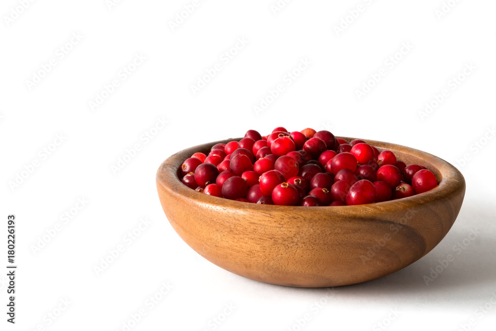 Berries of a cranberry in a wooden bowl on a white background isolate close-up