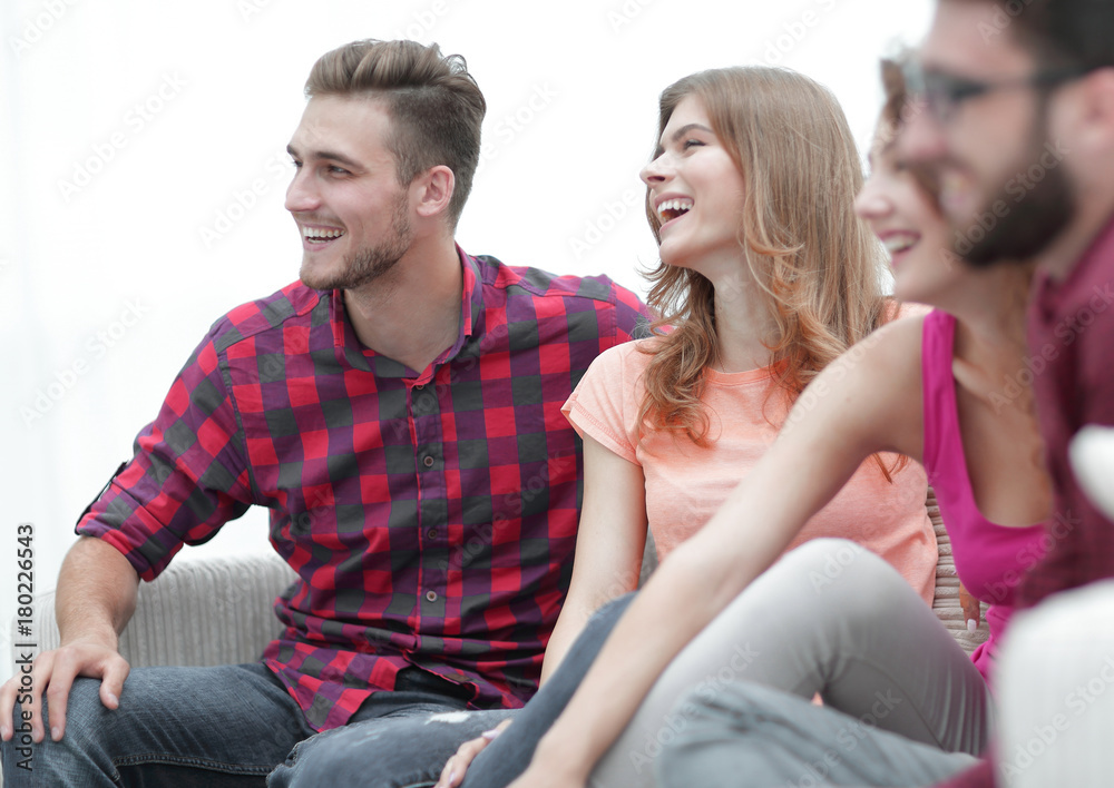 group of cheerful friends sitting on the couch