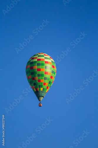 A beautiful colorful hot air baloon flying over the autumn swamp. Sunny wetland landscape in morning with balloon in Latvia.