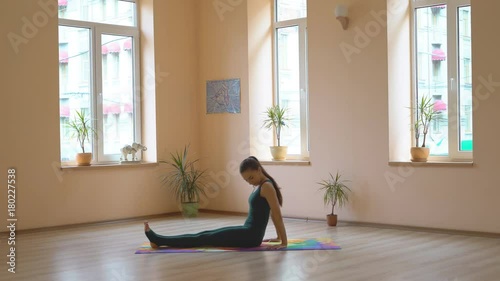 A professional yoga instructor demonstrates a set of healing enhancements for strengthening the muscles of the legs and buttocks. Multiseries video. Young attractive brunette girl is engaged in a