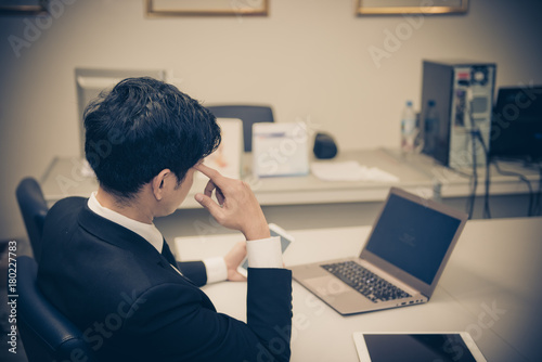 Businessman stress from hard work on the desk at office dark tone © reewungjunerr