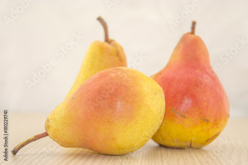 Fresh, juicy pear on a wooden base and white background color