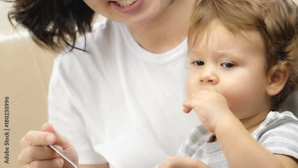 Mother feeding her one-year-old baby boy with a spoon.
Mother feeding her one-year-old baby boy with a spoon.
