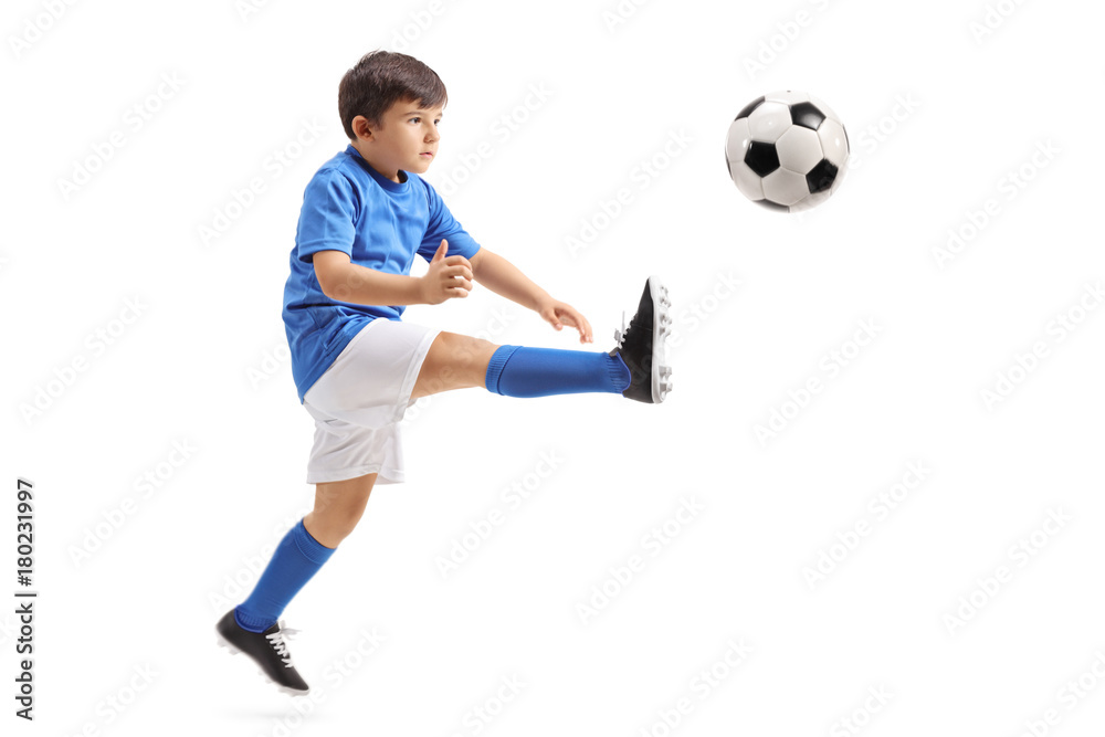 Little soccer player kicking a football in mid-air