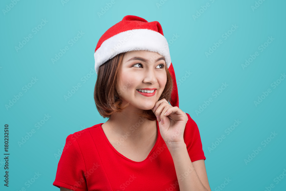 Smiling asian woman portrait with christmas santa hat isolated on blue background. Smiling asian woman portrait with christmas santa hat isolated on blue background.