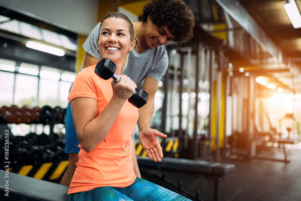 Young beautiful woman doing exercises with personal trainer Young beautiful woman doing exercises with personal trainer