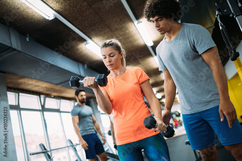 Young beautiful woman doing exercises with personal trainer