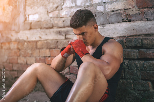 Portrait of handsome muscular boxer who resting after training.