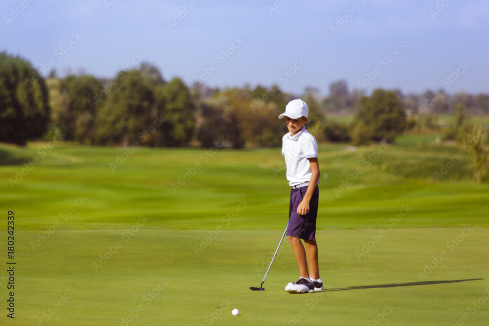 Boy golf player practicing at green, disappointed after fail shot