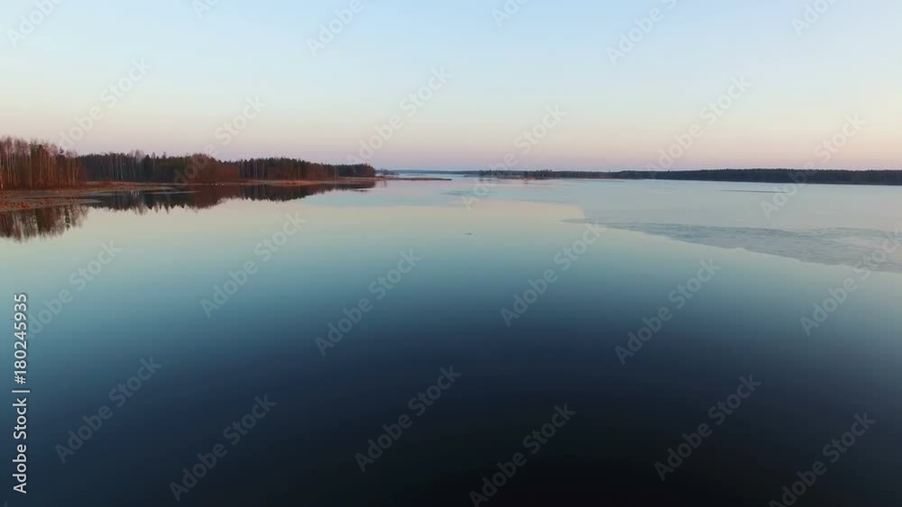 4K. Low flight over wild frozen lake in winter on sunset, aerial view. 4K. Low flight over wild frozen lake in winter on sunset, aerial view.