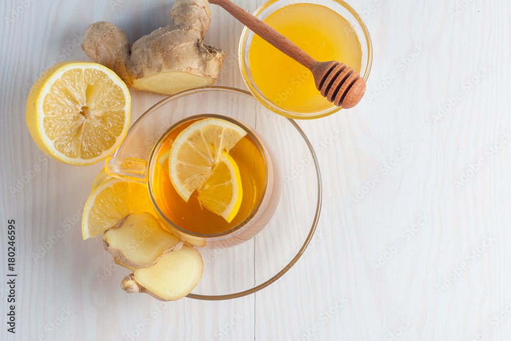 A glass cup of green natural tea with ginger, lemon, mint and honey on wooden rustic background. Healthy drink. A glass cup of green natural tea with ginger, lemon, mint and honey on wooden rustic background. Healthy drink.