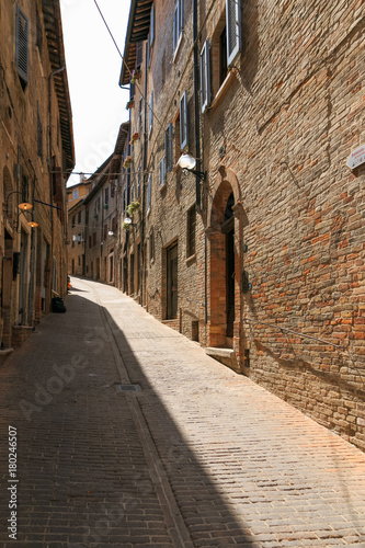 Fototapeta Naklejka Na Ścianę i Meble -  Urbino, Italy - August 9, 2017: A small street in the old town of Urbino. sunny day.