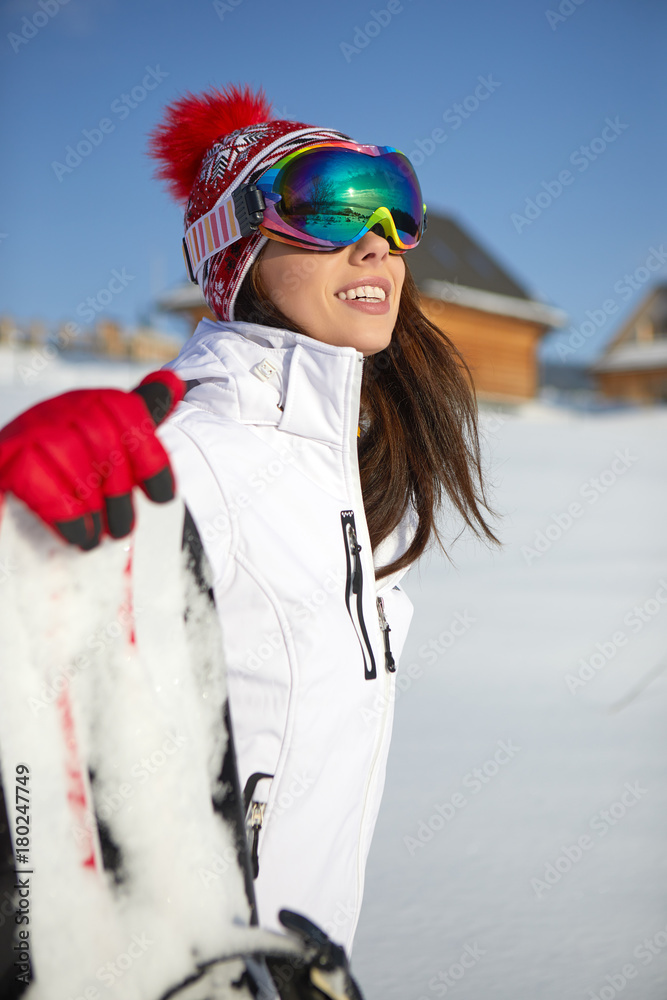 Sporty female holds snowboard in mountains