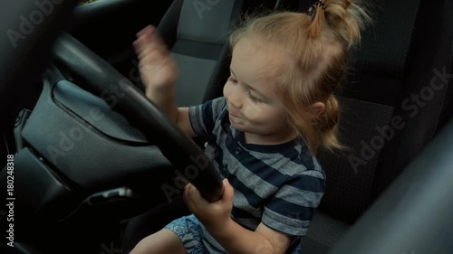 Happy driver, horn car alarm warns of danger. Horn on car goes beep. Handsome happy boy doing beep on auto horn. Happy childhood, fun on the road. Smart boy learns from his father to drive a car photo