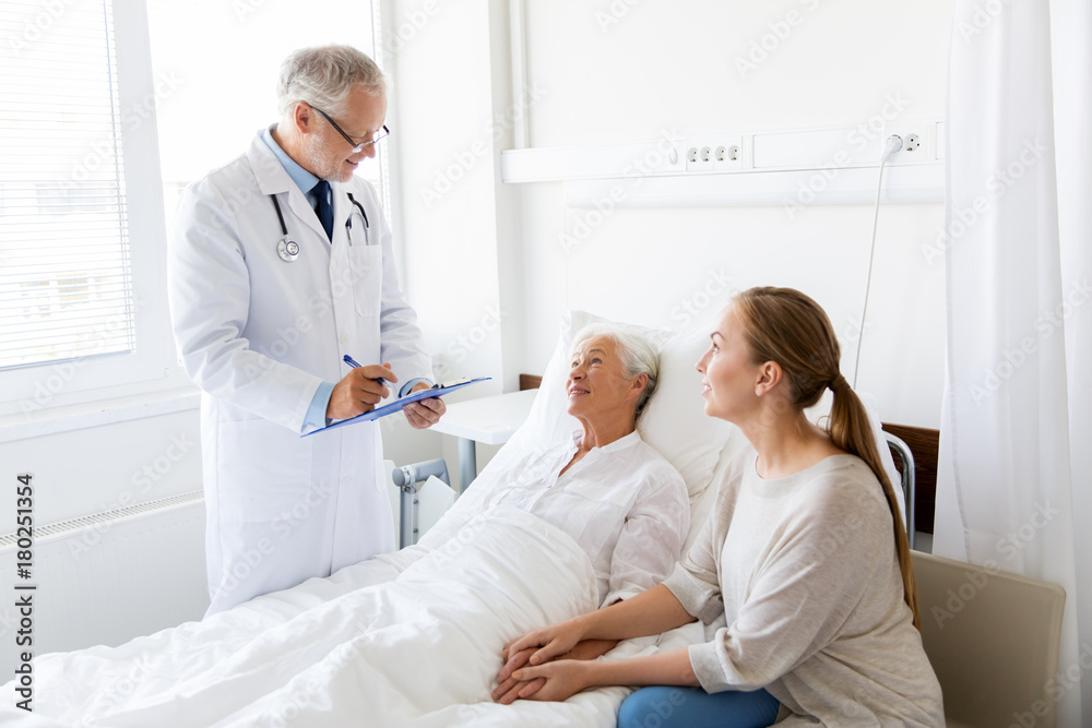 Obraz premium senior woman and doctor with clipboard at hospital