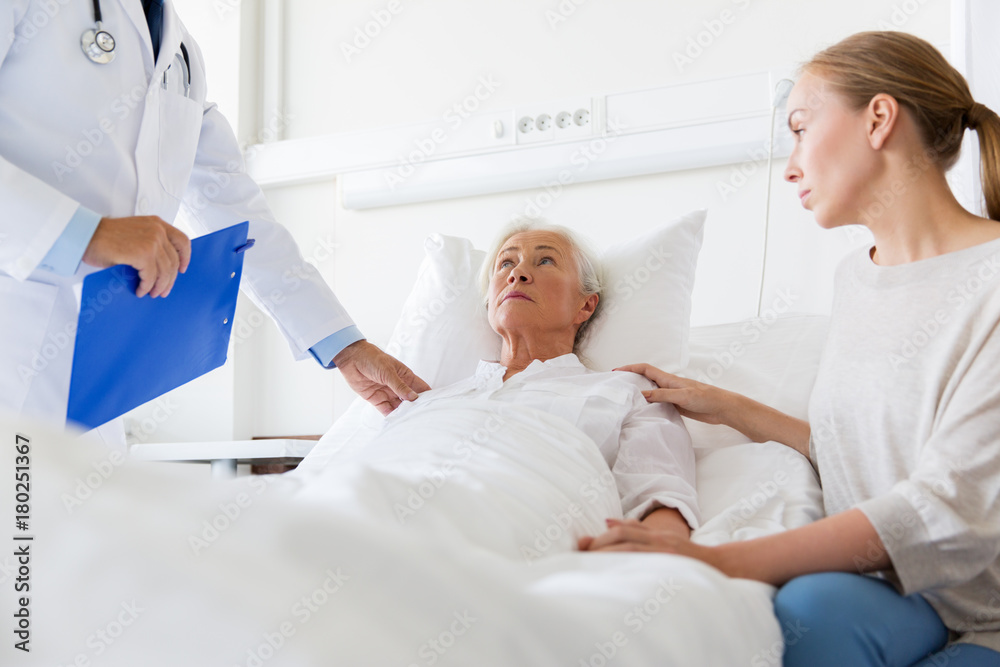 Fototapeta premium senior woman and doctor with clipboard at hospital