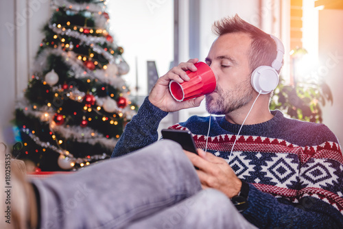 Fotografi Men drinking coffee and listening music with feet up