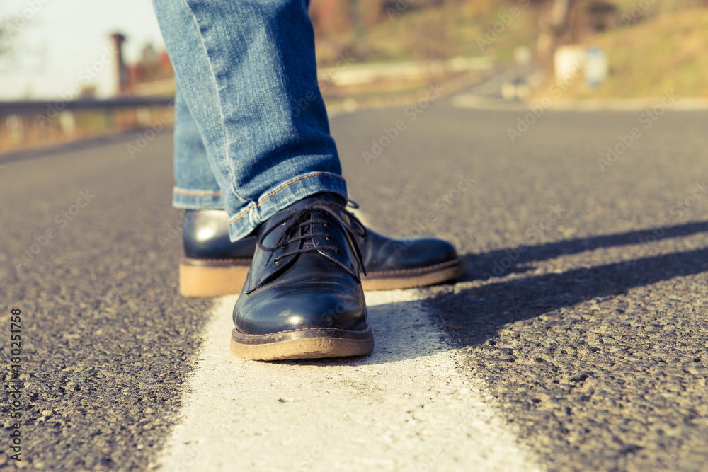 Closeup of woman autumn shoes in the middle of the road