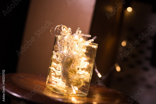 LED light bulb in glass cup on wood chair photo