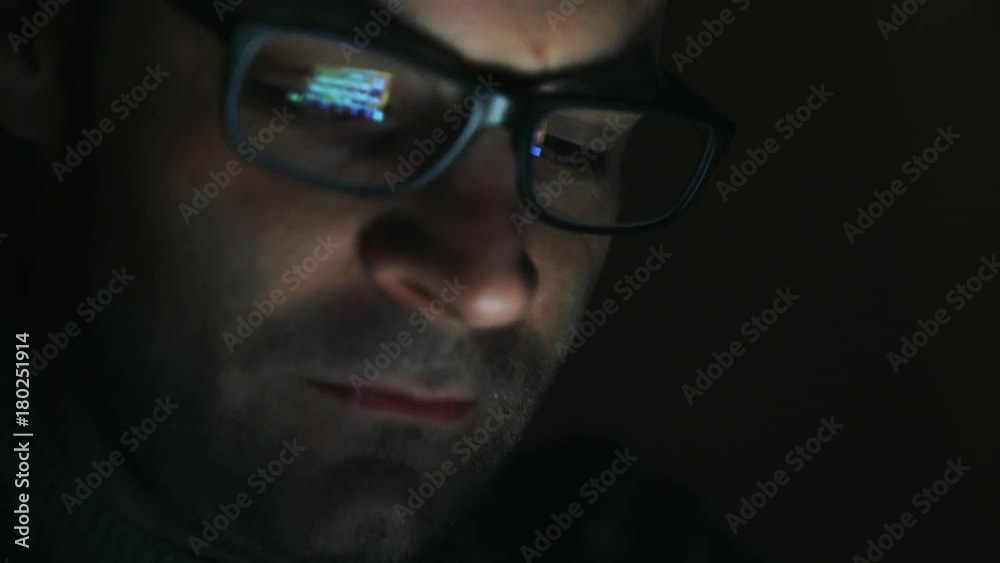 Gambling addicted man with glasses in front of online casino slot machine on laptop computer at night - loosing his money. Dramatic low light grain shot. Gambling addicted man with glasses in front of online casino slot machine on laptop computer at night - loosing his money. Dramatic low light grain shot.