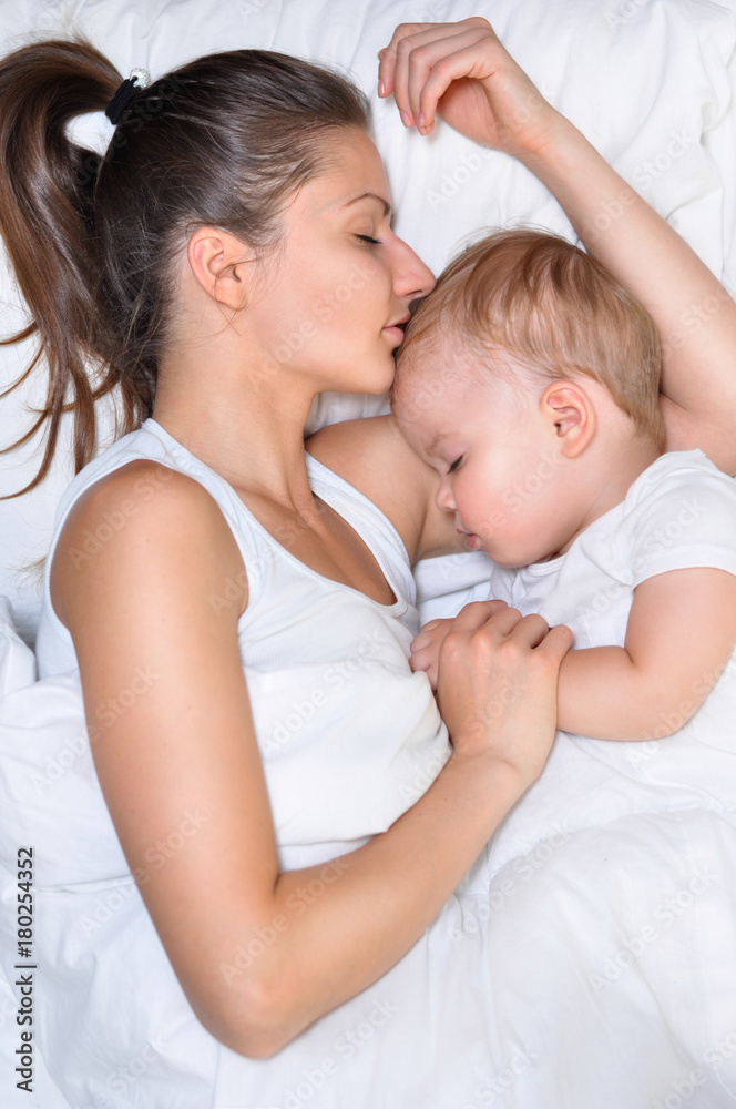 young beautiful woman mother holds the hand of her sleeping child
young beautiful woman mother holds the hand of her sleeping child