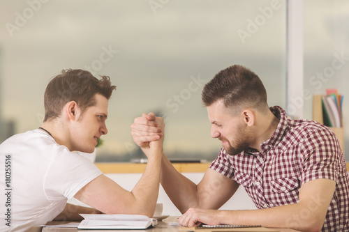 Businessmen armrestling at work photo