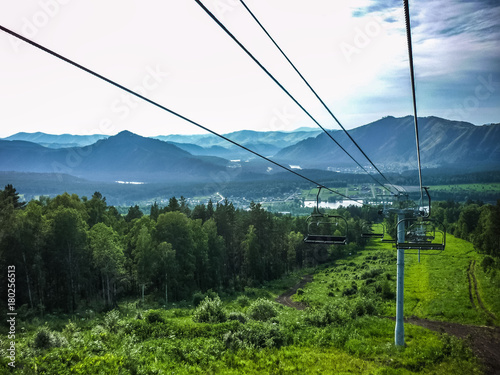 Emtpy chairlift in ski resort. Shot in summer with green grass and no snow. Smoke on the mountains.