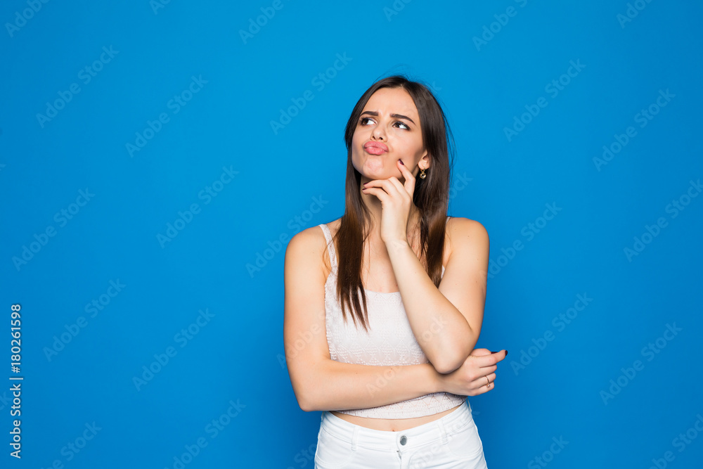 Portrait of grumpy moody girl standing isolated over blue background Portrait of grumpy moody girl standing isolated over blue background