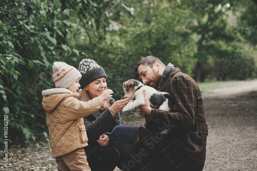 Happy family playing with dog fox terrier Outdoor