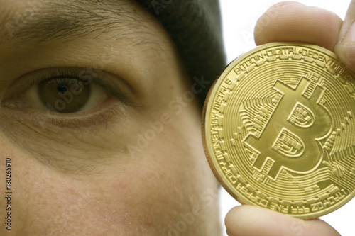 mad bitcoin lover with a gold coin in your hand , funny miner with BTC near the face photo