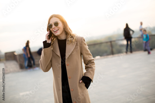 Young woman with eyeglasses with mobile phone outdoor