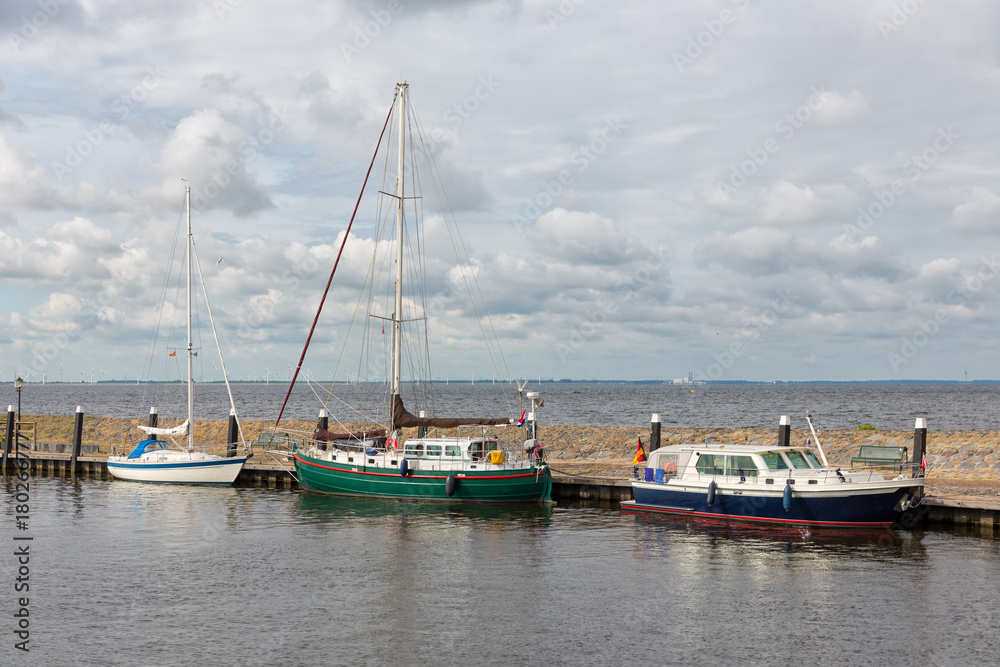 Harbor of historic Dutch village Urk with modern sailing yachts moored to a pier